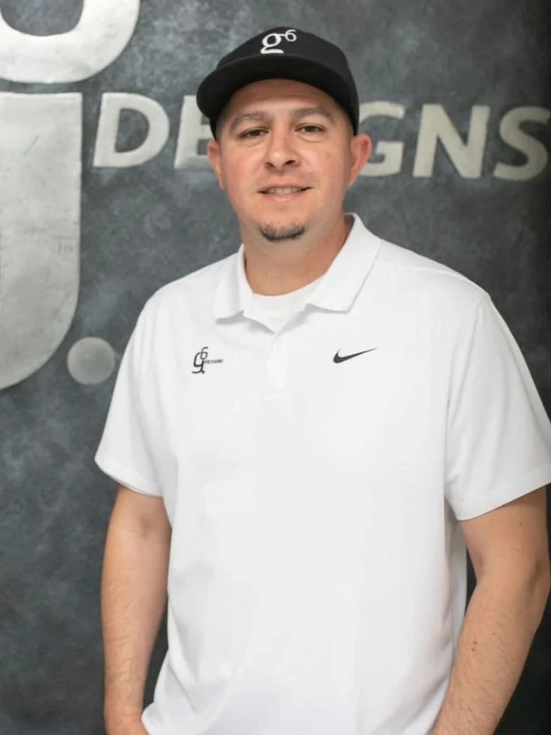 Vic Garcia, founder of G6 Designs, in front of the G6 Designs logo wall